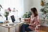 A woman makes notes while sitting at a desk